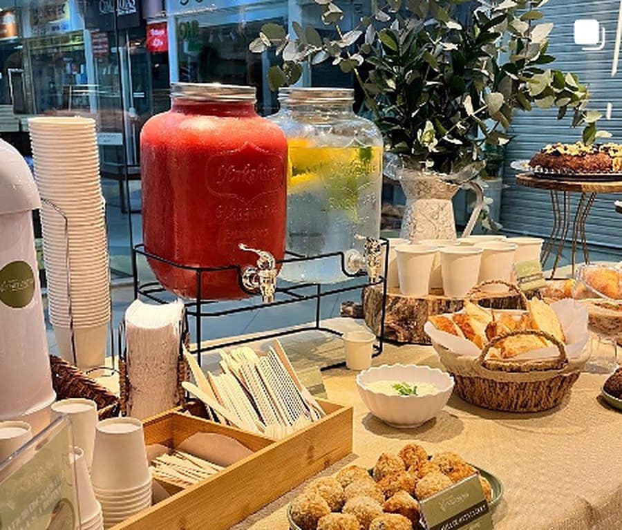 Mesa de evento Dona Natureba com sucos, coxinhas e quiches